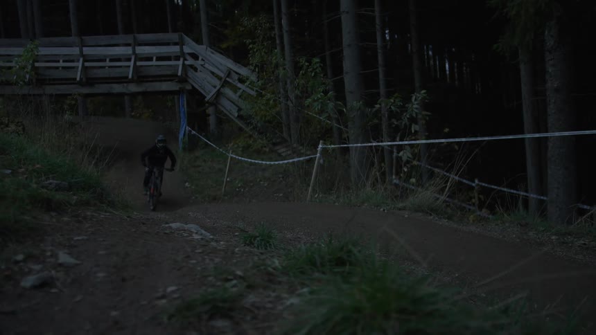 Man letting go of a small mountain bike hill in the forest
