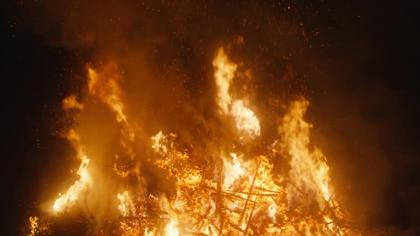 Flames rise from a blazing bonfire in the darkness