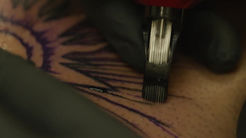 A clip of a person getting a tattoo on the body