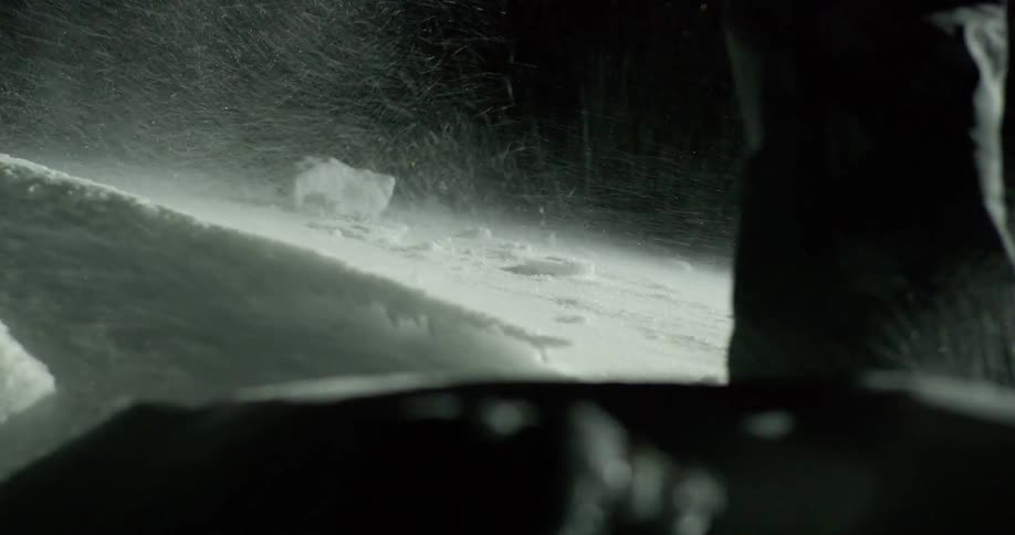 Closeup of a persons leg hiking on a snowcovered mountain at night
