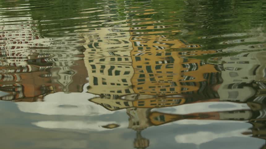 Reflection of an urban city in a moving lake