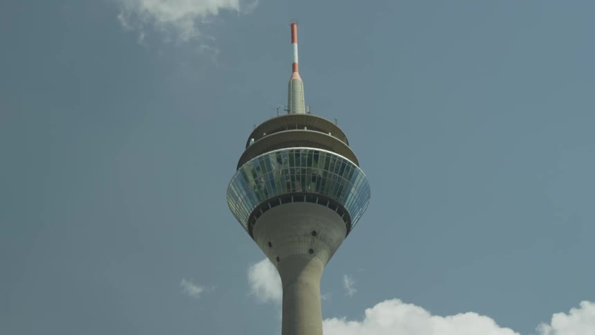 Upward view of a cable car tower on a blue sky day with clouds