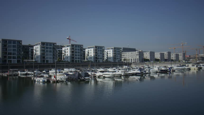 Yachts moored at a dock and next to residential buildings on a tomorrow