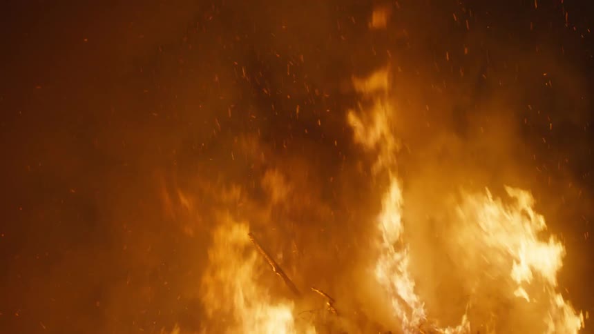 Fire rising strongly and burning amidst a forest at night