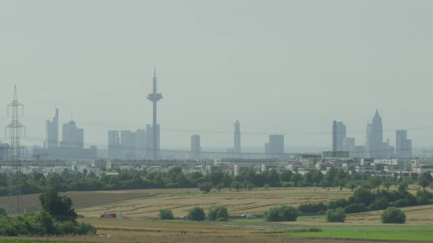Landscape of a field and in the background a metropolis with skyscraper towers