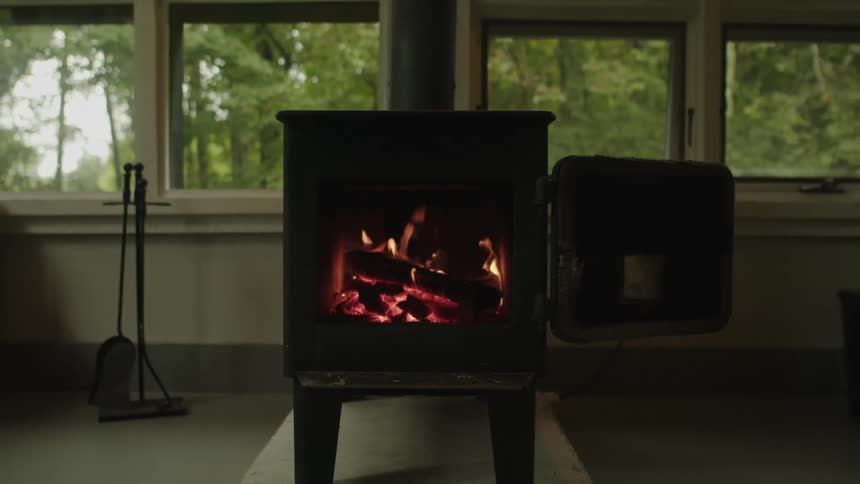 A cozy room with a woodburning stove and a view of nature
