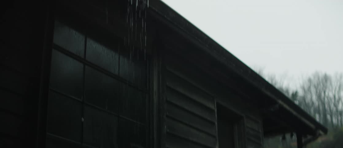 Rain falls on a decrepit building