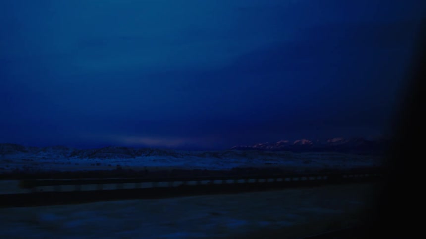 A view from inside a car window of the horizon with snow on the ground