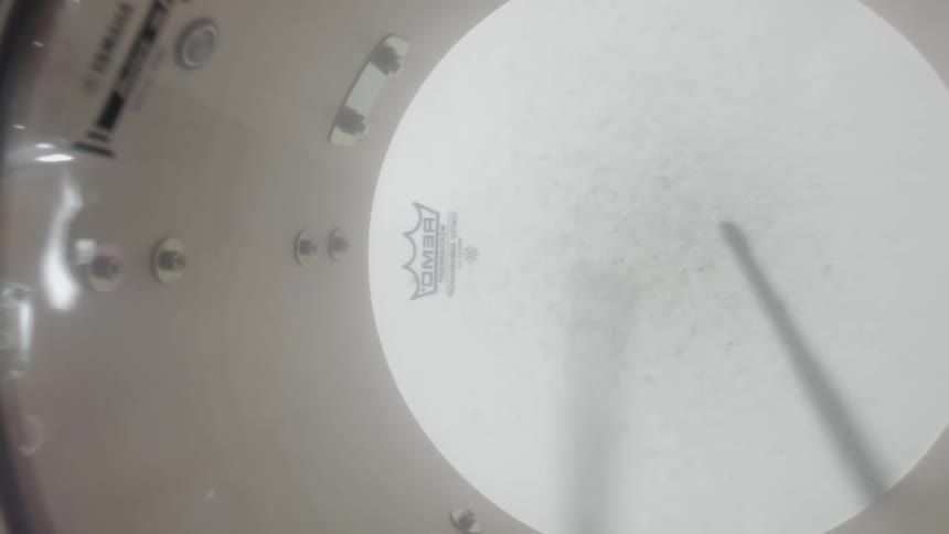 A clip of a drum and the shadow of a drum stick beating