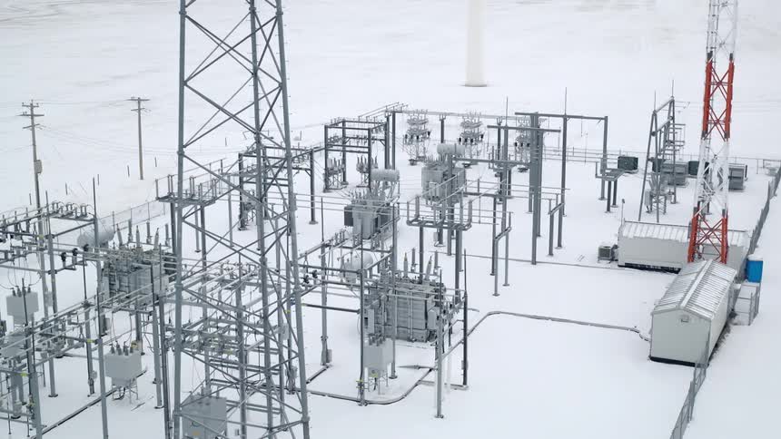 Aerial of power towers and substation in the snowcovered countryside