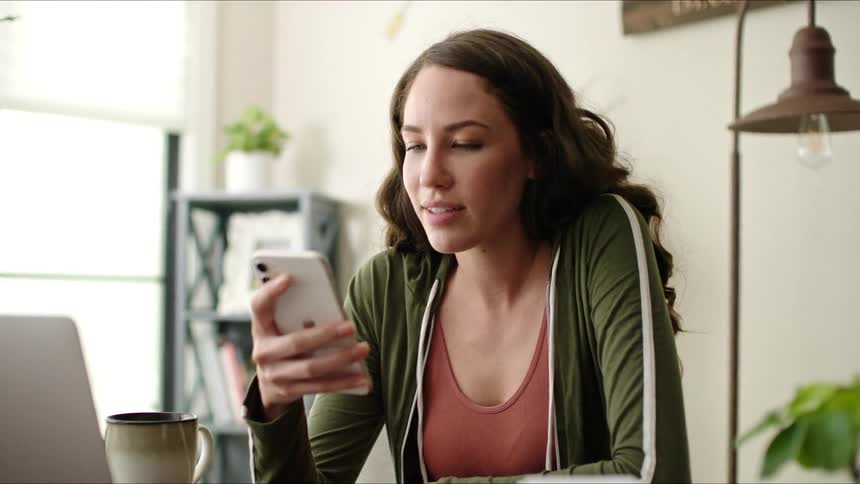 Woman sitting using her cell phone and smiling