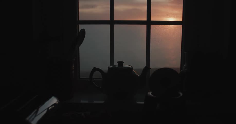 The sea is seen from the kitchen window during sunset