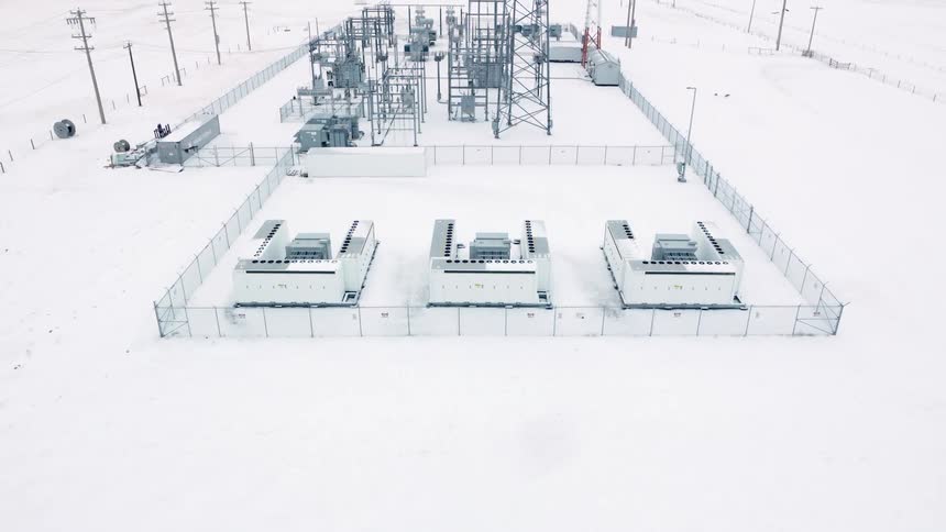 A battery grid energy storage station on snowy landscape