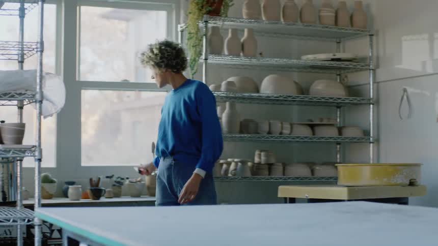 Woman organizing her work environment where there are porcelain vases