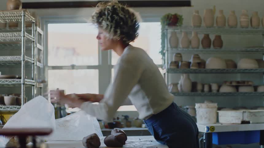 Woman kneading clay dough on the table