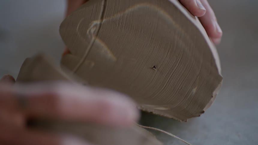 Person splits a molded clay into two equal halves