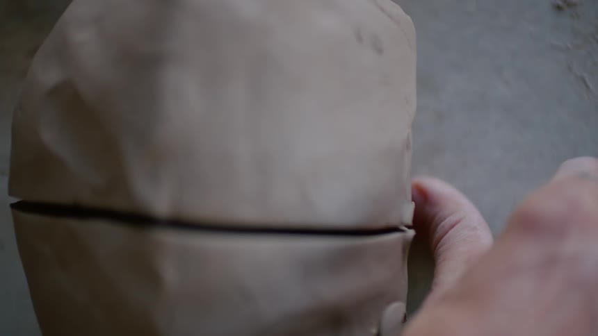 A person cutting a clay mold to two
