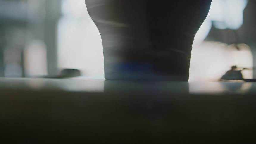 A clay pot is rotating on a rotating plate