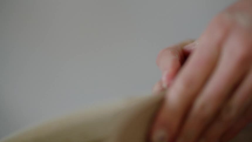 Closeup of a womans hands manually holding a clay pot