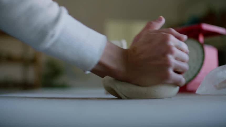 Hands of a person who is kneading a piece of clay