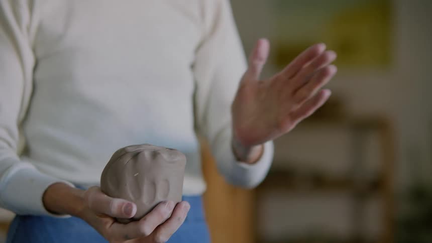 Womans hands modeling a piece of clay