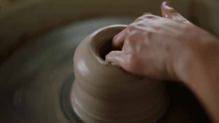 Hands of a female sculpturing on a sculpting wheel