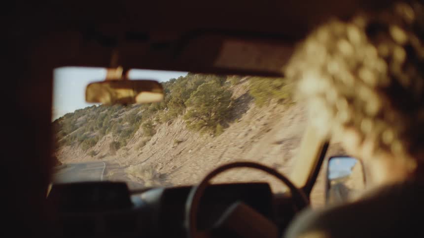 Woman driving a car in a natural environment