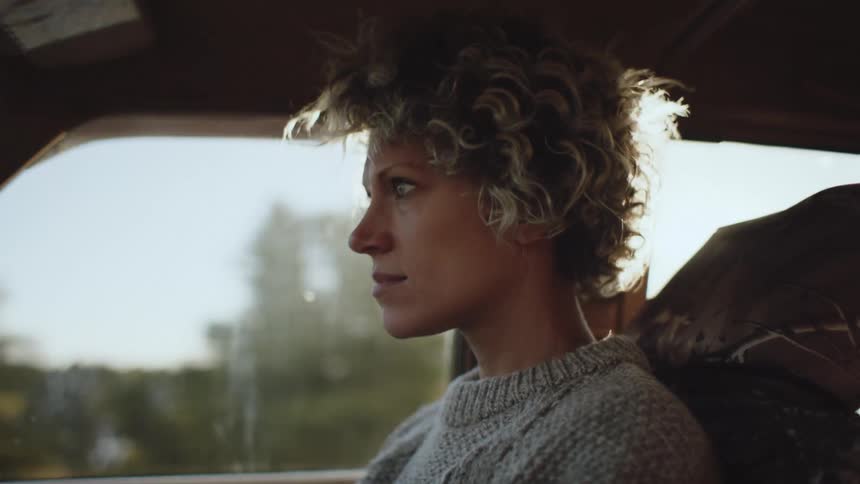 Closeup of a womans face driving a car during the day