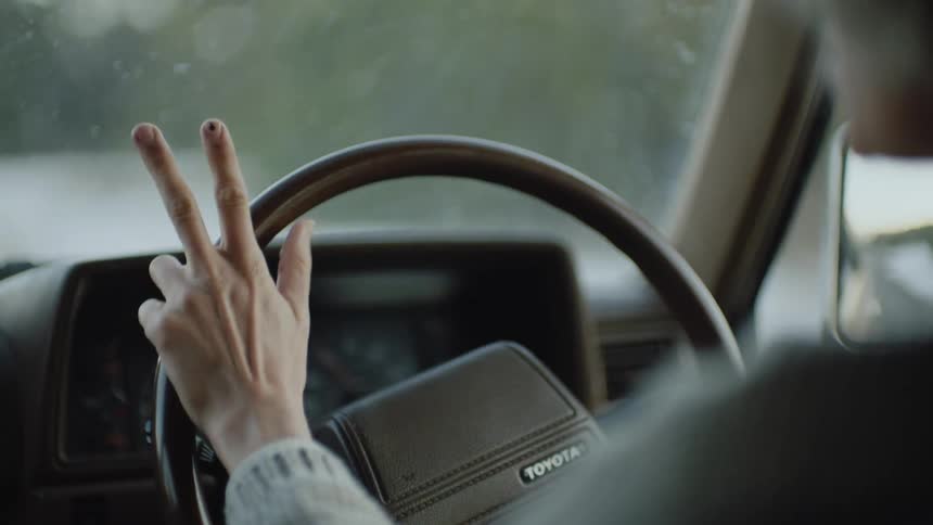 Closeup on the steering wheel with a womans hands driving the car