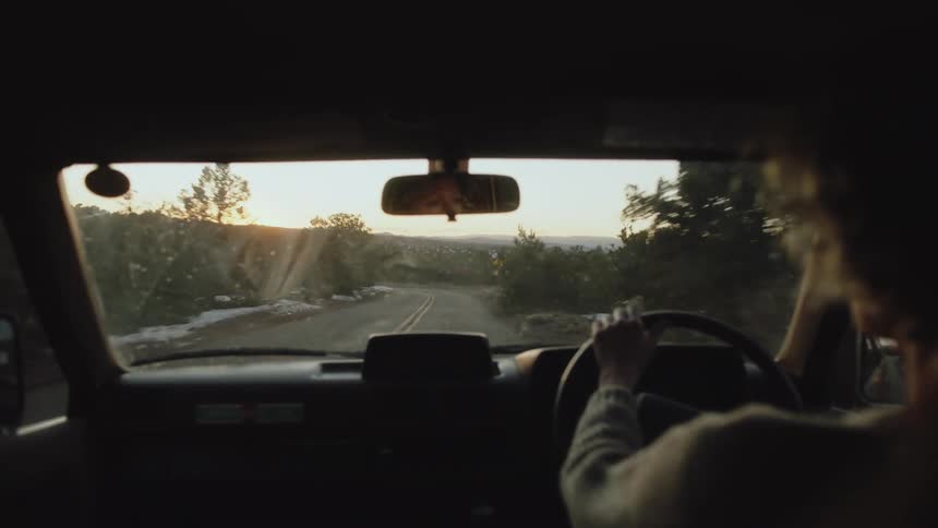 A woman driving a car down a road