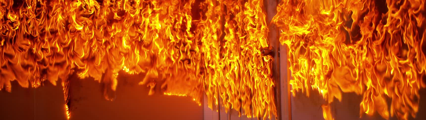 Flames flow upward on door and building wall