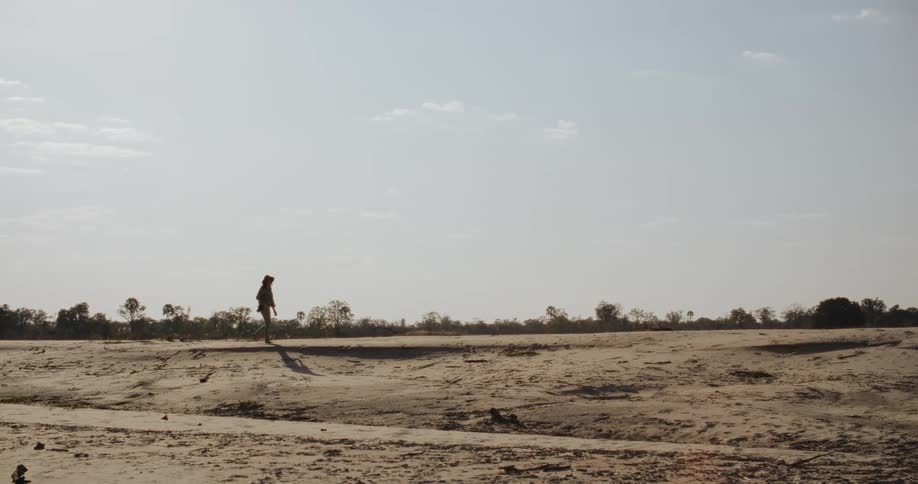 A person walks across a flat terrain