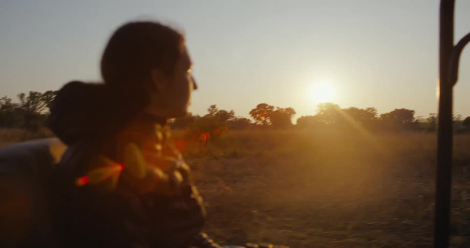 Portrait of a woman riding a safari with a sunset on the horizon