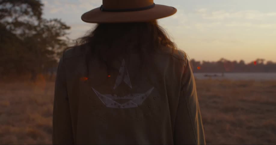 View of a woman from behind walking at a post next to a lake in the late afternoon