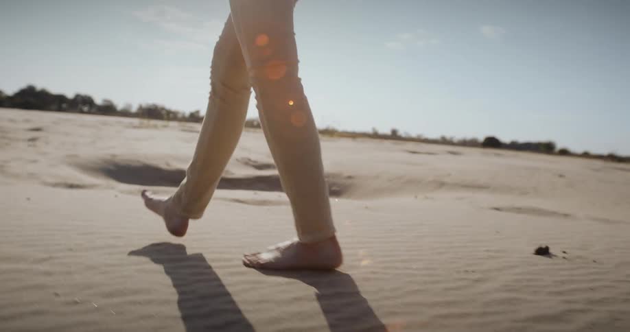A woman walking barefoot in desert sands