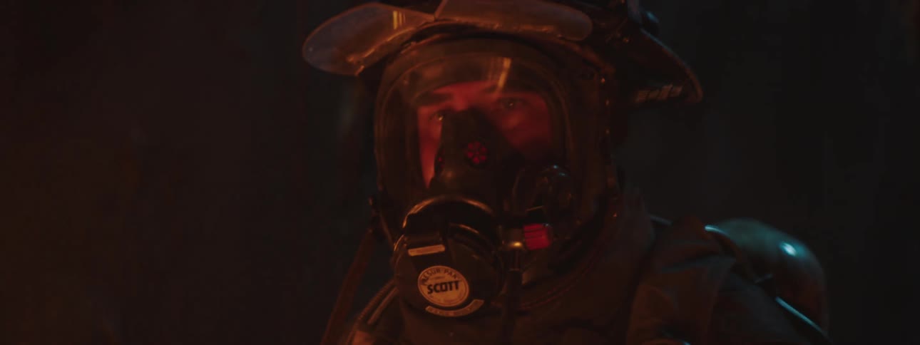 Firefighters transparent face cover reflects fire at night