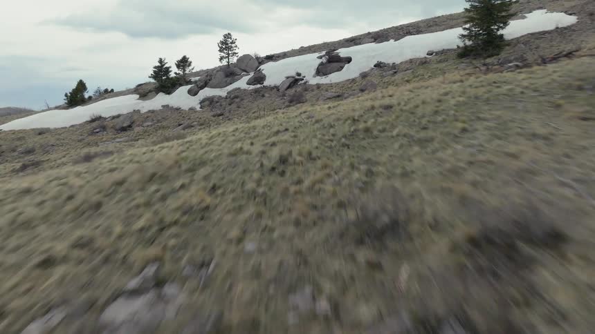 A mixture of barren and green land in the hills under a cloudy sky