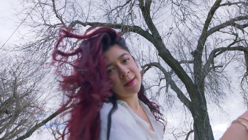 A young woman swings her head so her hair flows around her