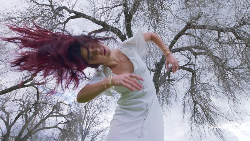 A woman is dancing on a cloudy day