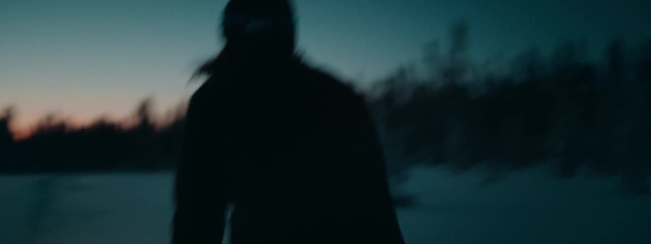 A woman snow skiing in a forest at night