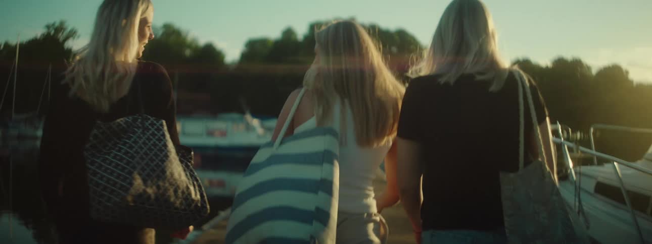 Three women walking across a marina