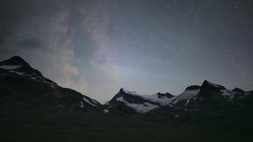 Starry sky illuminating the mountains with snow