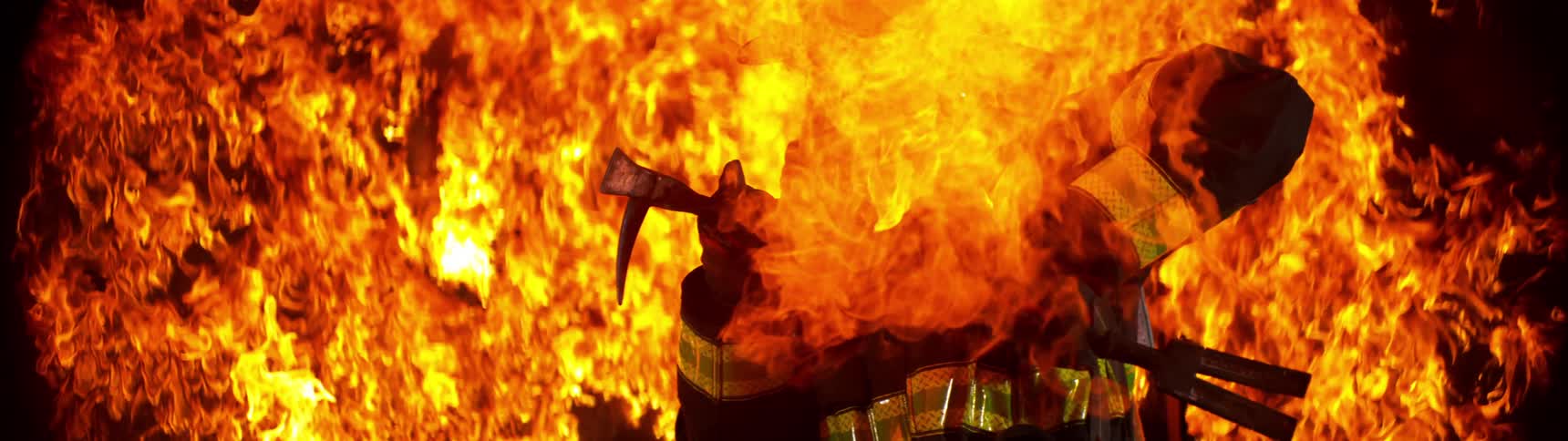 A fire fighter trying to escape flames but getting enveloped by them