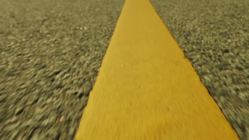 Close up of the yellow line on the asphalt of a road