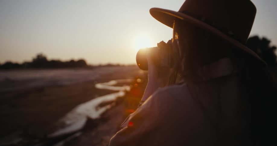 A woman with a camera takes a photo of nature