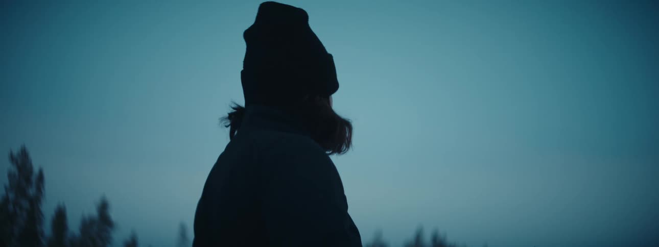 A woman looks around on a cloudy day