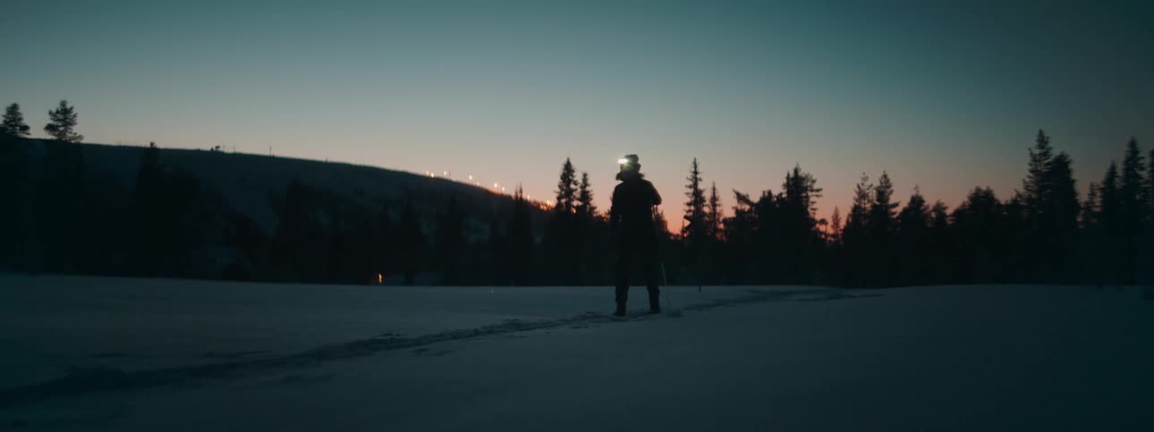A woman walking on skis over a snow covered plain
