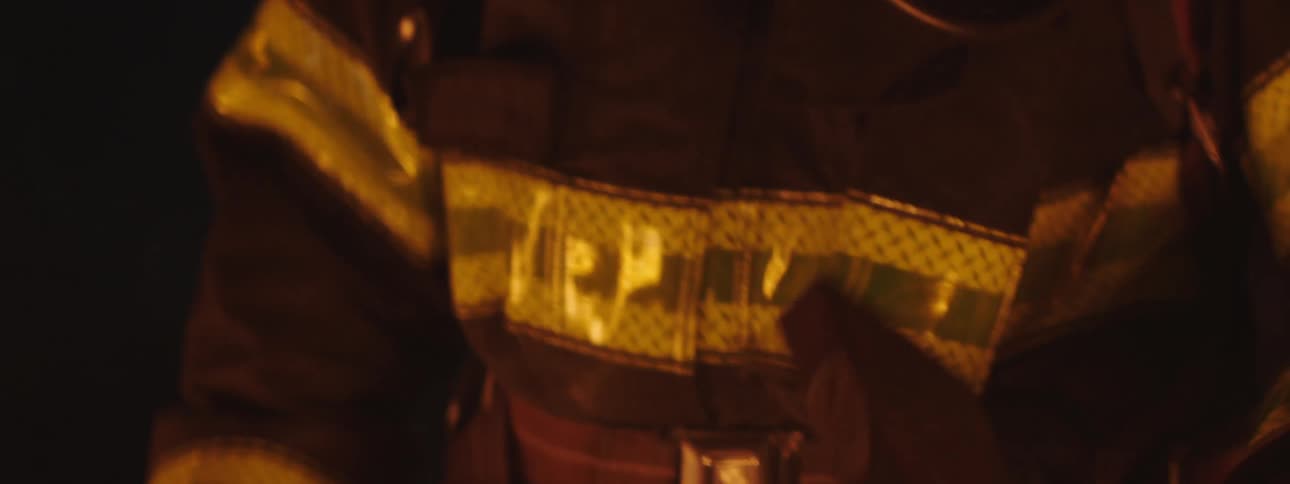 A firefighter passes an ax from one hand to the other