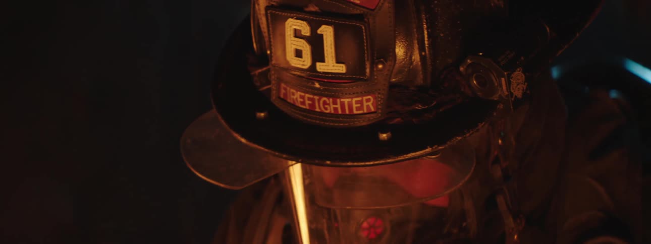 A firefighter wearing a protection helmet and mask a fire reflecting in the visor