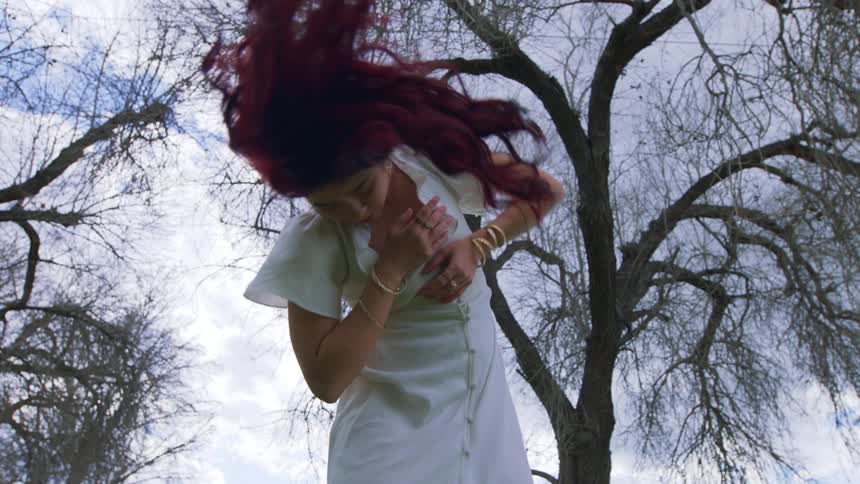 A woman is dancing by the tree